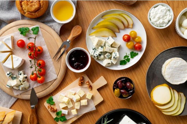 Different types of food items served on dishes, including cheese, tomatoes, etc.